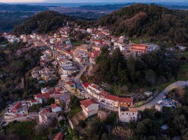 Gün batımında tepedeki köyde, yeşil tepelerin arasında. Büyüleyici evler ve dolambaçlı yollar manzaralı..