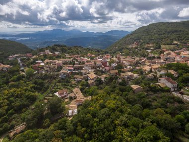 Yeşilliğe gömülü tepedeki köy manzaraya bakıyor..