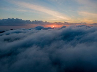 Bulutların üzerinde gün batımı. Yukarıdan nefes kesici bir manzara, doğanın sanatının güzelliğini gözler önüne seriyor..
