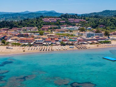 Sahil kenti sahnesi berrak turkuaz su, kumlu sahil ve yemyeşil otellerin arasına yerleşmiş oteller..