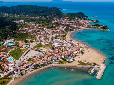 Sahil kenti hava manzarası: turkuaz sular, kumlu sahil ve kıyı şeridi boyunca yerleşik büyüleyici binalar..