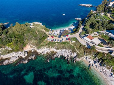 Kristal berraklığında turkuaz suyu, kumlu bir plajı ve park alanı olan tenha bir koy. Bereketli yeşillik bu cennet kıyı cennetini çevreledi..
