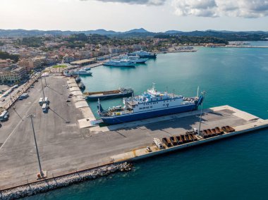 Limanı feribot ve kargo gemileriyle dolu. Kıyıdaki bir kasabanın deniz faaliyetlerini gösteriyor..