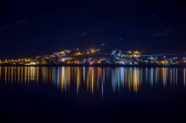 Gece ışıkları sakin suya yansıyarak büyüleyici bir yansıma efekti yaratır..