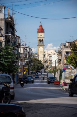 A charming street scene with a tall bell tower as a focal point, surrounded by residential buildings and everyday life. clipart