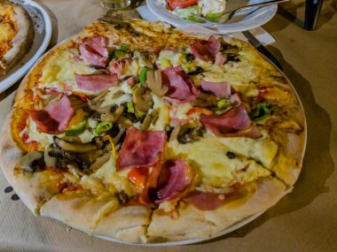 Korfu, korfu, Yunanistan. 13 Eylül 2020: Jambon, mantar ve sebzeli lezzetli pizza.