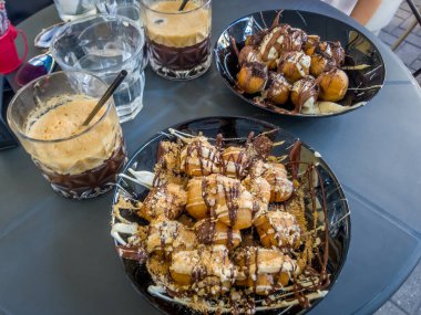 Korfu, korfu, Yunanistan. Kasım 06, 2020: Buzlu kahveli Yunan loukoumades çöreği