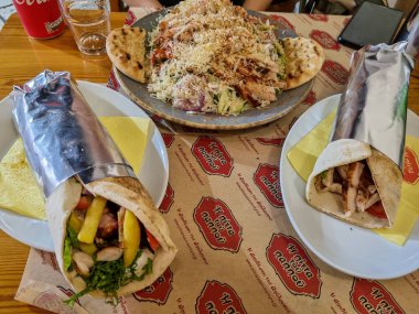 Korfu, korfu, Yunanistan. 01 Eylül 2021: H Pitta tou Pappou restoranında Yunan jiroskopu ve salatası