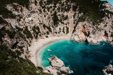 Turkuaz suyu olan tenha bir koy ve dramatik uçurumların arasına kurulmuş kumlu bir sahil..