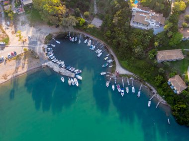 Sayısız teknenin kenetlendiği sakin bir körfezin havadan görünüşü.