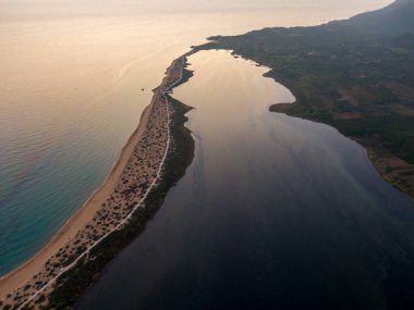 Sakin bir lagünü okyanustan ayıran kumlu bir yarımadanın havadan görünüşü.