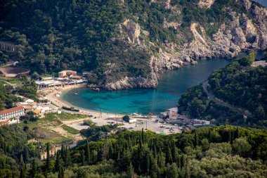 Bereketli yeşilliklerin arasına yerleştirilmiş sakin turkuaz koy..