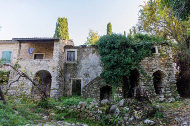 An abandoned stone house, weathered and overgrown with vines, evokes a sense of mystery. clipart