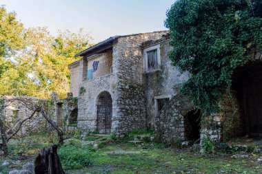 Kapısı kemerli eski bir taş ev..