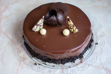 Dekoratif talaşlı ve beyaz çikolata aksanlı parlak çikolatalı pasta..