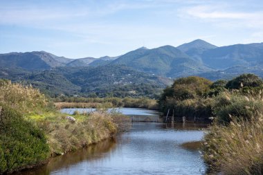 Huzurlu bir nehir dağlarla dolu sakin bir arazide akıyor..