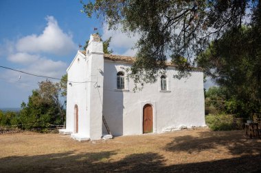 Kırsal alanda güneşli bir gökyüzünün altında beyazlatılmış bir şapel..
