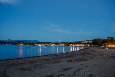 Sahilde gece çöker, sakin sahil kasabası aydınlanır..