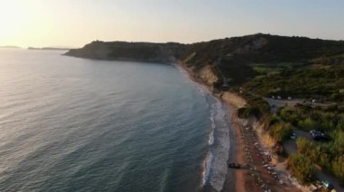 Gün batımında Arillas plajı, deniz ve kıyı kasabasının havadan görüntüsü. Korfu, Yunanistan