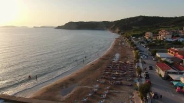 Gün batımında Arillas plajı, deniz ve kıyı kasabasının havadan görüntüsü. Korfu, Yunanistan