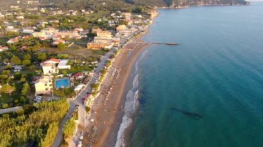 Gün batımında Arillas plajı, deniz ve kıyı kasabasının havadan görüntüsü. Korfu, Yunanistan