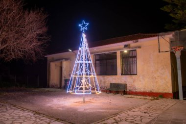 Işıklı Noel ağacı gece binanın yanında..