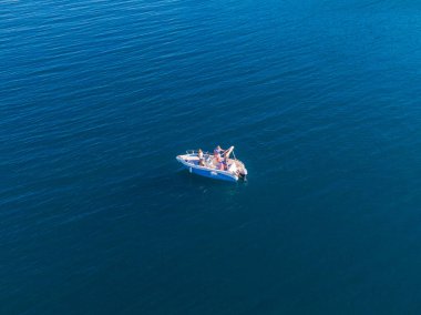 Uçsuz bucaksız mavi bir okyanusta küçük bir motorlu tekne..