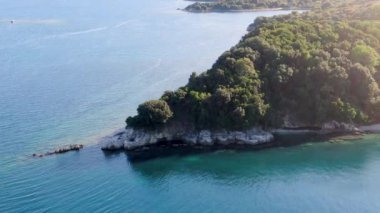 Bereketli yeşil bir yarımadanın canlı turkuaz bir denize saplanışının havadan görüntüsü. erimitis corfu greece