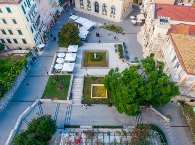 Yeşillik ve binalarla dolu bir kasaba meydanının havadan görünüşü.