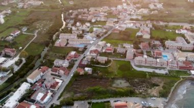 Tepelere kurulmuş bir sahil kasabası üzerindeki günbatımının insansız hava aracı görüntüsü