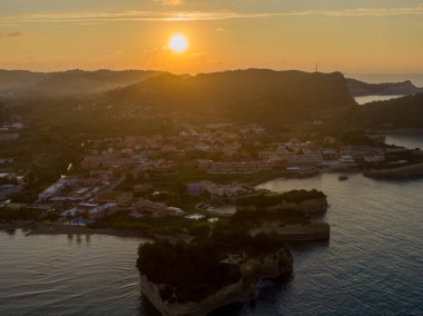Şehir ve denizin üzerinde gün batımı, hava manzarası.
