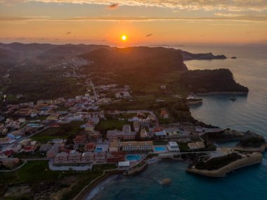 Sahil kasabasının günbatımı hava manzarası. Altın saat binaları ve denizi aydınlatır..