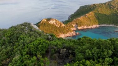 Korfu adası hava manzaralı turkuaz renkli güzel bir göl ve beyaz bir tekne, Korfu Yunanistan 'daki Porto Timoni plajı üzerinde uçuyor, Yunan adalarının Akdeniz doğası.