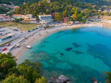 Aerial drone view of clear turquoise waters on the sandy Palaiokastritsa beach on the Aegean island of Corfu, Greece. clipart