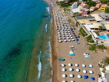 Yunanistan 'ın Korfu adasındaki Agios Gordios egzotik plajı. Agios Gordios plajı, Korfu adası, Yunanistan. Agios Gordios plajının panoramik manzarası, kumlu deniz kıyıları, plaj şemsiyeleri ve şezlonglar..