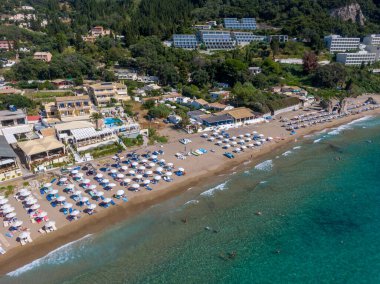 Yunanistan 'ın Korfu adasındaki Agios Gordios egzotik plajı. Agios Gordios plajı, Korfu adası, Yunanistan. Agios Gordios plajının panoramik manzarası, kumlu deniz kıyıları, plaj şemsiyeleri ve şezlonglar..