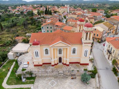 Aerial view of a church in a quaint village nestled amongst rolling hills. clipart