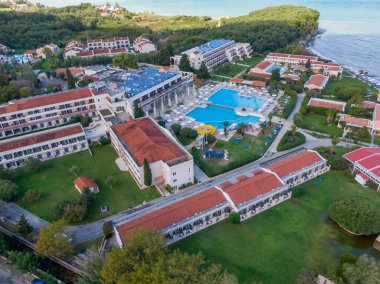 Havuzu ve binaları olan bir sahil beldesinin havadan görünüşü.