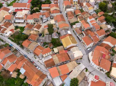 Kırmızı kiremit çatılı ve dar sokaklı bir köyün hava manzarası.