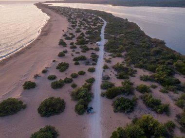 Kıyı yolu kumulların arasından tenha bir plaja doğru esiyor..