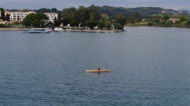 Güneş doğarken turkuaz gölde kano süren adam, korfu, Yunanistan