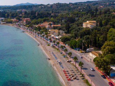 Sahil kenti sahil manzarası, turkuaz su, palmiye ağaçları.