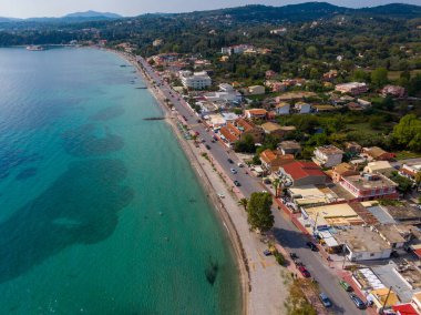 Sahil kenti hava manzarası: turkuaz su, sahil, yol, binalar.