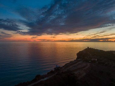Kıyı tepesinden okyanusun üzerinde gün batımı.