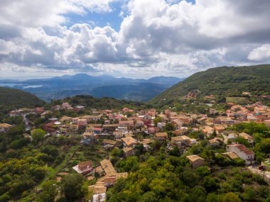 Yeşilliğe gömülü tepedeki köy manzaraya bakıyor..