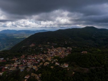 Dramatik gökyüzü altındaki tepe köyü, hava manzarası.