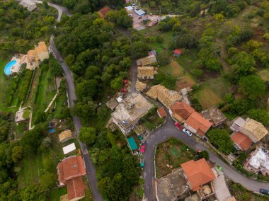 Yeşil bir arazide yuva yapmış tuhaf bir köyün havadan görünüşü..