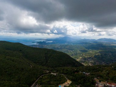 Dramatik bulutların altındaki kıyı dağlarının panoramik görüntüsü.