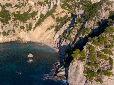 Koyda kayalık kayalıklar ve turkuaz su var..