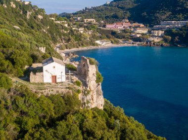 Sahil şapeli ve harabeler sakin bir körfeze bakıyor. Huzur ve tarih buluşuyor.